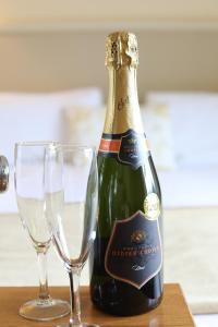 基拉尼基林之家酒店的一瓶香槟和一张桌子上的两杯酒