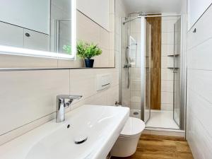 博尔滕哈根Dünenblick Wohnung 40的白色的浴室设有水槽和卫生间。