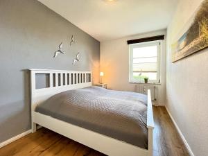 博尔滕哈根Dünenblick Wohnung 40的卧室配有一张墙上鸟床