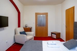 雷德尼斯斯托克瑞莱克斯酒店的一间卧室配有一张床、一把椅子和电视