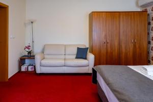 雷德尼斯斯托克瑞莱克斯酒店的卧室配有白色沙发和椅子
