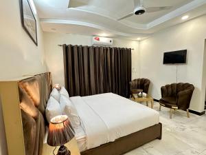伊斯兰堡Dream Executive Guest House的酒店客房,配有一张床和两把椅子