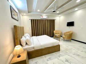 伊斯兰堡Dream Executive Guest House的一间卧室配有一张床,并在一间客房内配有电视。