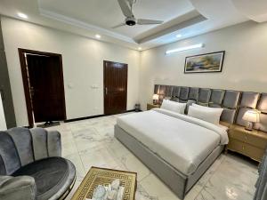 伊斯兰堡Dream Executive Guest House的一间卧室配有一张床、一张沙发和椅子