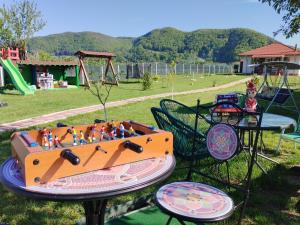 皮亚特拉-尼亚姆茨Desculti prin iarba- la 6,6 km de centrul Piatra Neamt的公园里一张桌子和游戏设备