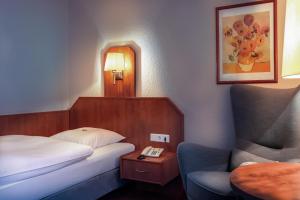 汉诺威Hotel Münkel的配有一张床和一把椅子的酒店客房