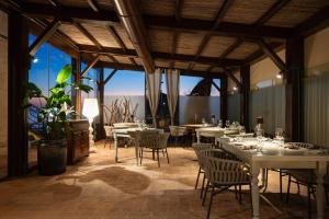福洛尼卡Relais Torre Mozza - Dimora d' Epoca的用餐室设有桌椅和窗户。