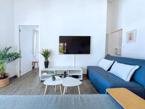 Anse Marcel Villa Romane private pool breathtaking sea view的客厅配有蓝色的沙发和电视