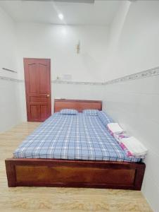 Ấp Rạch MẹoNHÀ NGHỈ NHẬT ANH的一间卧室配有一张带蓝色格子床垫的床