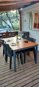 Orgnac-lʼAvenMobile home的甲板上的木桌和椅子