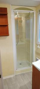 Orgnac-lʼAvenMobile home的浴室里设有玻璃门淋浴