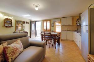 特乌拉达Vacanze Mare Teulada的带沙发的客厅和带桌子的厨房