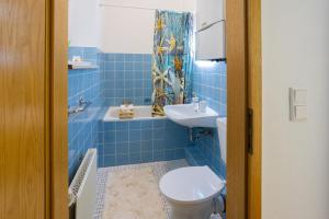 波鸿ruhrApartments #Nähe A40 #zentral #fastWIFI #perfekt für Familien und Geschäftsreisen的蓝色瓷砖浴室设有卫生间和水槽