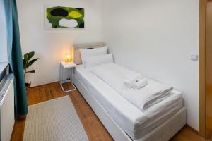 波鸿ruhrApartments #Nähe A40 #zentral #fastWIFI #perfekt für Familien und Geschäftsreisen的一张白色的小床,位于带灯的房间