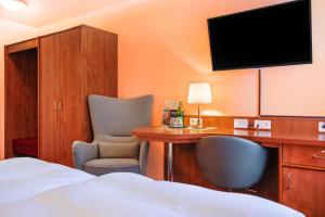 汉诺威Hotel Münkel的酒店客房设有一张床、一张书桌和一台电视机。