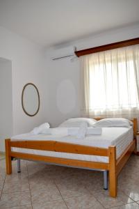 卡萨米尔Ksamil Sea&Lake view Escape的一间卧室配有一张木床和窗户