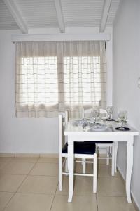 卡萨米尔Ksamil Sea&Lake view Escape的白色的餐桌,配有两把椅子和窗户