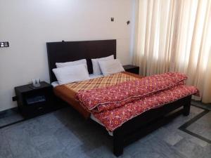 穆扎法拉巴德Kashmir Inn Hotel的一间卧室配有一张大床,并可以避免