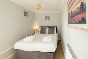 Aldringham1 Hazelwood, Aldeburgh的一间卧室配有一张带白色床单的大床