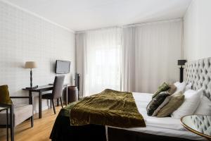 Ösmo科润达高尔夫及会议酒店的一间卧室配有一张床和一张书桌