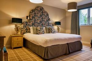 Stanton HarcourtThe Harcourt Arms的一间卧室配有一张大床和大床头板