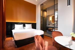 鲁尔蒙德范德瓦尔克橘园剧院酒店的卧室配有一张床和一张桌子及椅子
