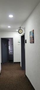 杜伊斯堡Duisburger Hostel的走廊上设有两扇门,墙上有时钟