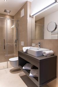 滨湖采尔Spa Apartments - Zell am See的一间带水槽、卫生间和淋浴的浴室
