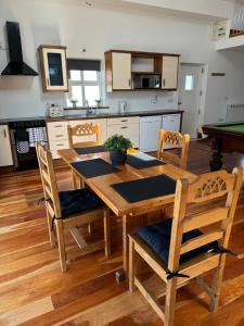 BrackhillDe Búrca Cottage KERRY的厨房配有木桌、椅子和台球桌