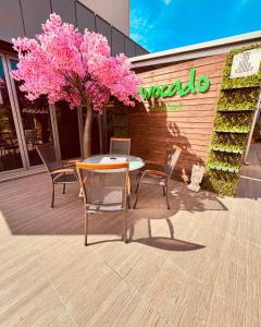 普罗夫迪夫Plaza Hotel Plovdiv的一张桌子和椅子,一棵树上种着粉红色的花