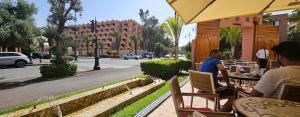 马拉喀什Marrakesh Pearl Gardens Amazing 2 Bedrooms apartment的坐在街上桌子上的两个人