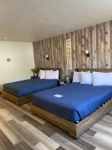 WhitehallJefferson Inn的配有蓝色床单的客房内的两张床