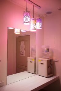 台中市安顺商务旅馆的一间设有粉红色墙壁和2台冰箱及灯的房间