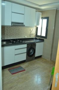 非斯حي الأدارسة فاس的厨房配有白色橱柜和洗衣机。