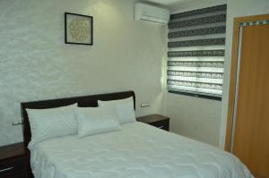 非斯حي الأدارسة فاس的一间卧室配有一张带白色床单的床和一扇窗户。