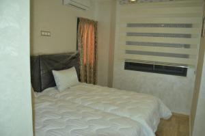 非斯حي الأدارسة فاس的卧室配有白色的床和窗户。