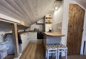 苏提万Eco Chalet Style Apartment的厨房配有白色橱柜和木制天花板