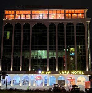 代胡克Lara Hotel的一座大型建筑,晚上有一间松弛酒店