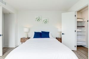 阿林顿2BR Comfort Apartment in Prime Location的白色卧室配有一张带蓝色枕头的大床