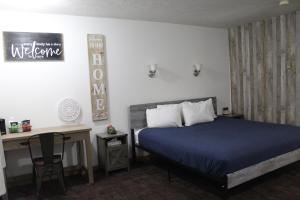 WhitehallJefferson Inn的一间卧室配有一张床、一张桌子和一张四柱床。