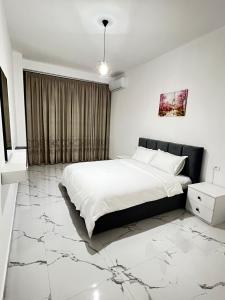 LushnjëPrime Luxury Apartments的一间铺有大理石地板并配有白色大床的卧室