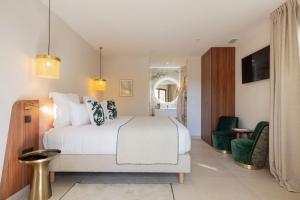 卡布列斯La Bastide Bourrelly - Mathias Dandine的卧室配有白色的床和绿色椅子