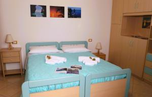 潘泰莱里亚LE CASE DI CICCIO - Casa Girasole的一张蓝色的床,上面有毛巾和书籍