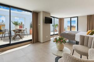 阿利坎特El Pont Alicante Apartments的一间卧室配有一张床,阳台配有桌子