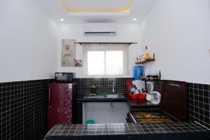 蒙巴萨Beau Fahy Nyali studio apartment的一间小厨房,配有黑色瓷砖柜台和水槽