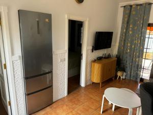 英格兰海滩Bungalow near Yumbo的厨房配有冰箱、桌子和电视。