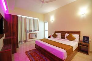 新德里Hotel Franklein Suites At Delhi Airport的一间卧室配有一张大床和电视