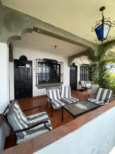 圣佩德罗拉拉古纳Mikaso Hotel的庭院配有椅子、玻璃桌和桌子