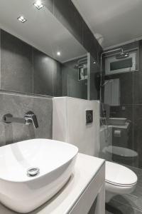 OrestiadaNo125 - City Centre Studio Apartment的浴室配有白色水槽和卫生间。