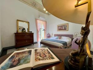 拉古萨Palazzo d'Autore - Luxury Home - Ragusa Centro的一间卧室配有一张床和一张桌子及一本书
